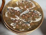 a plate with a picture of people on it next to a bowl with a lid