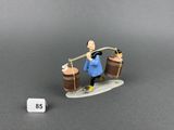 une figurine représentant un homme sur une planche de surf, avec deux vagues tubulaires