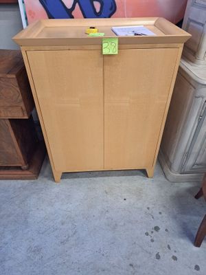 une armoire en bois sur laquelle est accrochée une pancarte, dans une pièce