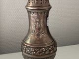 a silver vase that is sitting on a table