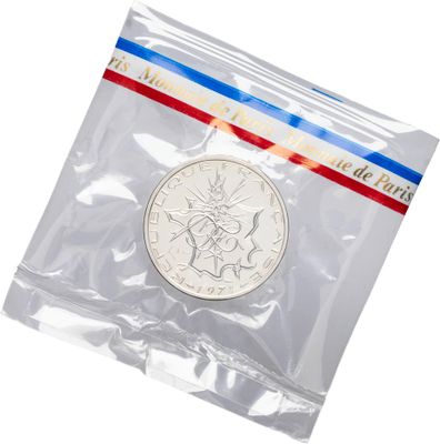 a close up of a coin in a plastic bag on a white background