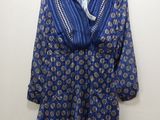 une photo d'une chemise bleue et blanche suspendue à un cintre