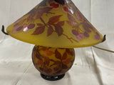 lampe de table en verre jaune et rouge ornée de feuilles, sur fond blanc