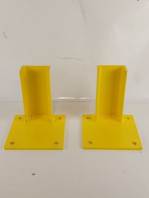 une paire de supports métalliques jaunes destinés à être fixés à l'arrière d'un camion