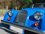 a blue vintage car parked on the side of the road
