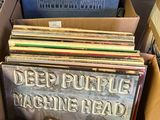 an open cardboard box filled with various records on top of a table