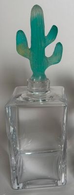 two small glass vases that have a cactus on top of them