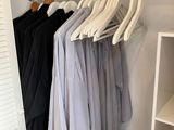 une photo d'un placard avec des vêtements suspendus à une tringle