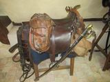 une selle et une paire de bottes sur une chaise
