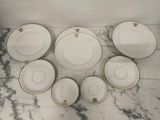 a group of white and gold plates on a marble table