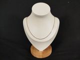 a close up of a white mannequin with a gold chain on it