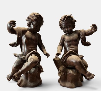 two statues of children sitting on top of a tree stump