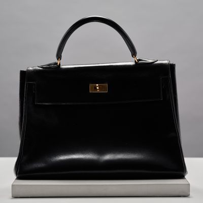 un sac à main en cuir noir posé sur une table blanche