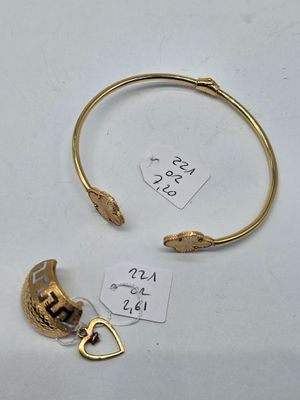 a close up of a gold bracelet with a bird on it