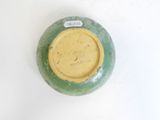 a green and yellow vase with a tag on it