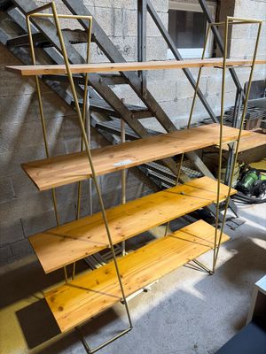 a wooden shelf with three shelves on it in a room