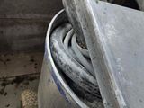 a metal container with a hose in it sitting on the floor