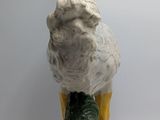 a white duck that is sitting on top of a green statue