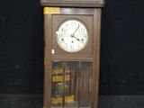 a wooden clock that is sitting on a black surface