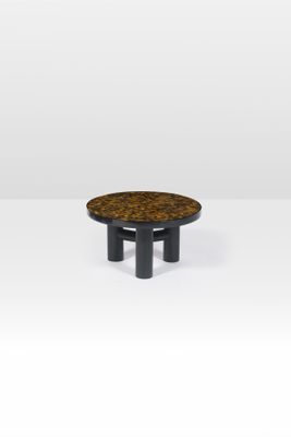 une table basse ronde avec des pieds noirs et un plateau en bois