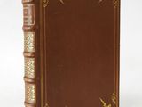 a brown leather book with gold trimming on the cover