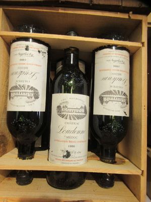 trois bouteilles de vin posées sur une étagère en bois