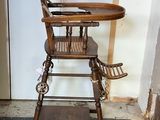 a wooden high chair that is sitting in the corner of a room