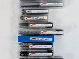 several pens are lined up in a row on a white surface