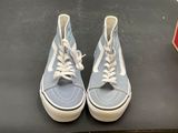 pair of blue and white vans sneakers on a black surface