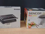 two boxes of food are sitting on a table next to a box of rice cookers