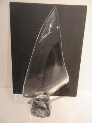 a glass sculpture of a sailboat on display in a glass case