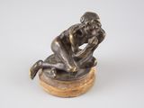statue en bronze représentant un homme assis sur un socle en bois, les mains sur le visage