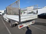 a white truck with a cage on the back of it in a parking lot