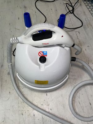 a white and blue steam iron sitting on a wooden floor