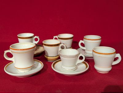 plusieurs tasses et soucoupes posées sur une nappe rouge