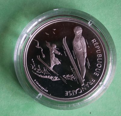 a picture of a silver coin with a skier on it