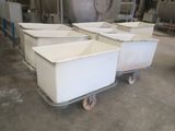 three white containers sitting on a dolly in a warehouse