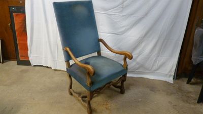 a blue chair that is sitting in front of a white curtain