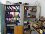many files and boxes on the shelves in the room