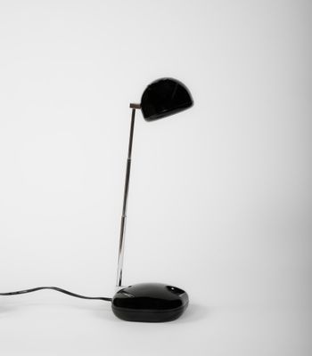 une photo en noir et blanc représentant une lampe de bureau et une souris