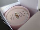 a white box with a pink lid and a white cup in it