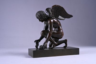 statue of a boy kneeling on a base with wings on his head
