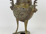 an antique bronze incense burner on a stand with a lid