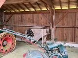 un vieux tracteur et une charrue dans une grange