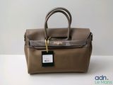 an image of a brown leather handbag with a tag on it