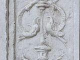 une plaque en pierre ornée d'un motif, fixée sur le mur d'un immeuble