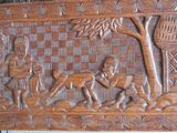 carved wooden panel depicting a man and a woman with a dog