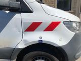 a white van with red stripes parked in front of a building