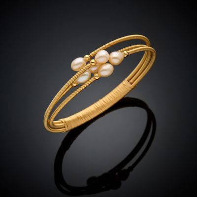 un bracelet en or orné de perles sur fond noir