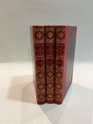 three red books sitting on top of each other on a white surface